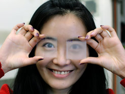 Mengyuan Li, with two thin PVDF samples: Opaque rough PVDF film via conventional processing on the right, and transparent smooth PVDF film via improved processing on the left.