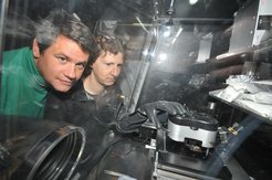 Rüdiger Berger (links) und Stefan Weber (rechts) beim Vermessen einer Solarzelle. Um die empfindlichen Schichten der Solarzelle vor Feuchtigkeit und Sauerstoff zu schützen, befindet sich ihr Kraftmikroskop in einer luftdichten Kammer, die mit einem Schutzgas gefüllt ist.